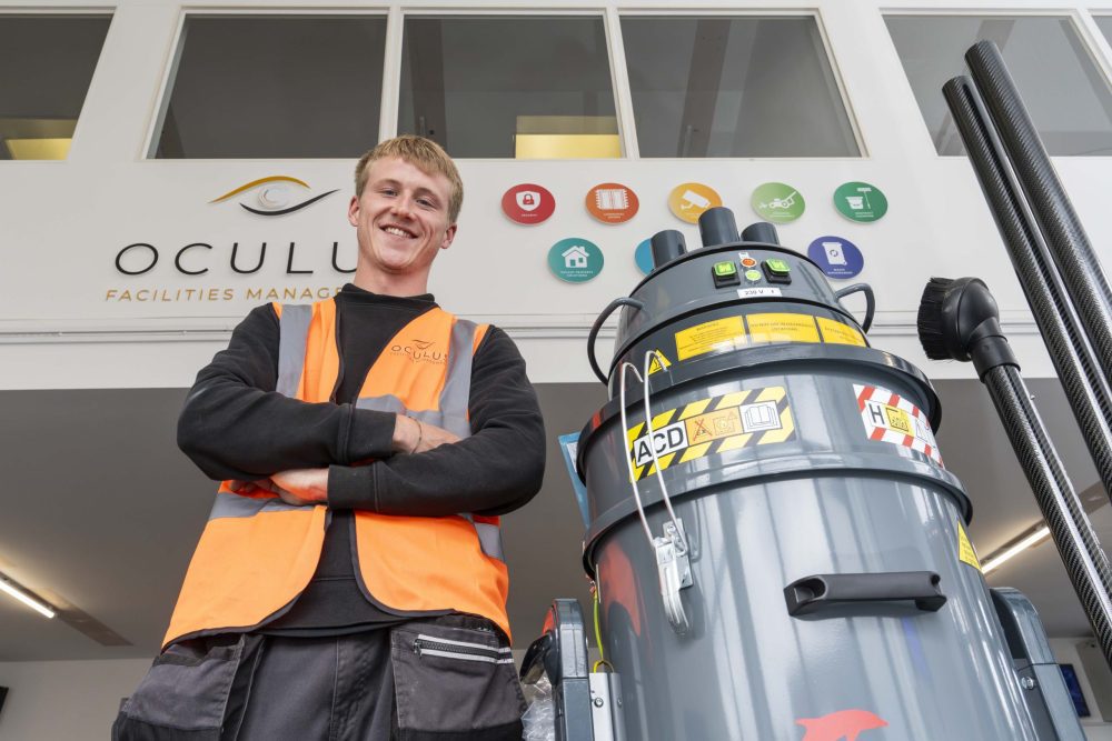 A professional cleaner with a specialist high reach vacuum cleaner.