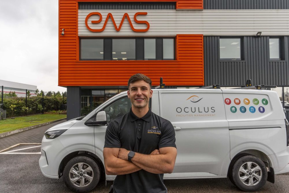 A security professional standing next to a branded Oculus FM van, on site with a client